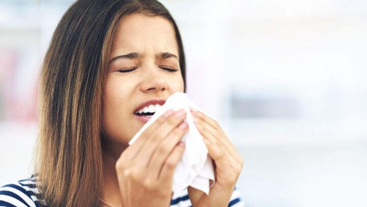 Woman experiencing seasonal allergies that may impact oral health and dental comfort.