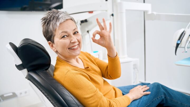Smiling patient showing restored teeth and improved bite with dental implants.