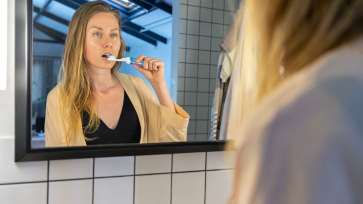 Woman brushing her teeth at home to prevent cavities.